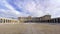 Esplanade and large courtyard of the royal palace of Madrid at sunrise on a day with blue sky and clouds