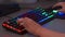 An esports player plays games on a gaming keyboard and mouse with RGB backlight