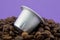 Espresso coffee capsule or coffee pod on coffee beans, purple background. Capsules