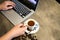 Espresso coffee in a cup of hot coffee and coffee beans,woman hands is working,using a computer,girl fingers typing on the