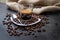 Espresso coffee in a glass cup on a black floor with coffee beans cutting light