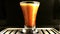 Espresso coffee preparing a drink in a coffee machine close-up. A transparent glass stack is filled with a stream of coffee with