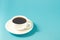 espresso cup on a blue background/white cup with a saucer full of black coffee on a blue background, selective focus