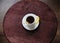 Espresso romano coffee with lemon in a white cup on a dark wooden round table top view