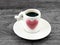 espresso shot in small coffee cup with embossed big purple heart and white saucer on dark gray rustic wooden table floor