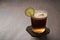 Espresso tonic in simple glass on walnut wood table with copy space