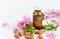 Essential almond oil, flowers and nuts on a white background
