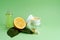 Essential, massage citrus oil, cream, serum with vitamin C, lemon extract on green background,