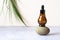 Essential natural oil in a brown bottle on a stone podium