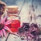 Essential oil bottle and coneflower on wooden board