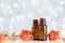 Essential oil bottles with rose flowers on white table with bokeh effect. Spa, aromatherapy, wellness, beauty background.
