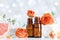 Essential oil bottles with towel, grapefruit and rose flowers on white table. Spa, aromatherapy, wellness, beauty background.