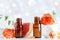 Essential oil bottles with towel, grapefruit and rose flowers on white table. Spa, aromatherapy, wellness, beauty background.