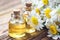 Essential oil in glass bottle with fresh chamomile flowers, beauty treatment. Spa concept. Selective focus. Fragrant oil of chamom