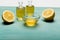 Essential oil in small bottles, honey in bowl and sliced lemon on wooden table