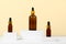 Essential oils on a beige background on white podiums, mockup. Cosmetic medical beauty product in brown glass bottles with a