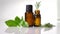 Essential oils in dark glass bottle with aroma herbs and Fresh leaves of basil and rosemary