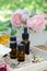 Essential oils with rose flowers and tea for aromatherapy treatment