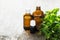 Essential oregano oil for aromatherapy in a dark glass containers on wooden background with fresh oregano. Selective