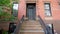 Establishing shot of brownstone building from stairs