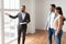 Estate Agent In Suit Showing Buyers New Empty Apartment