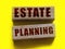 Estate planning words on wooden blocks on yellow. Real esate business concept