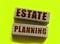 Estate planning words on wooden blocks on yellow. Real estate business concept