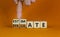 Estimate or evaluate symbol. Businessman turns wooden cubes and changes the word `evaluate` to `estimate`. Beautiful orange