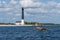 Estonia, Saaremaa Island. A white lighthouse rises high above the ground on the shore of the SÃµrve horn