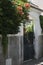 Estoril little street on summer time, stone fence with green outdoor plants with red flowers