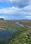 Estuary landscape, low tide with rain clouds