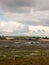 Estuary scene in manningtree with moored boats tide clouds lands