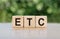 ETC word written on wooden blocks. The text is written in black letters and is reflected in the mirror