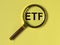 ETF acronym through magnifying glass on yellow background