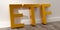 ETF - exchange traded funds - acronym in golden letters leaning against white wall on brown wooden floor background