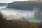 ethereal mist over valley, with alien creatures exploring the landscape