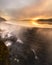 Ethereal moody sunrise with low fog and steam being illuminated over a lake and waterfall. Croton Gorge, NY