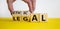 Ethical or legal symbol. Businessman hand turns wooden cubes and changes the word `legal` to `ethical` on a beautiful yellow t