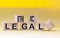 Ethical legal symbol. The words Ethical and Legal on wooden blocks and a beautiful yellow background. Business and ethical or