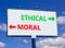 Ethical or moral symbol. Concept word Ethical or Moral on beautiful billboard with two arrows. Beautiful blue sky with clouds