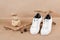 Ethical vegan shoes concept. A pair of white sneakers with dry flowers on the wood and pile of stones, neutral beige craft paper