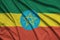 Ethiopia flag is depicted on a sports cloth fabric with many folds. Sport team banner