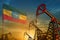 Ethiopia oil industry concept. Industrial illustration - Ethiopia flag and oil wells against the blue and yellow sunset sky
