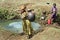 Ethiopian girls fetching water in natural water well