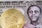 An Ethiopian one birr bank note with a gold, physical Bitcoin close up