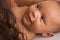 Ethnic biracial baby boy lying down by mother