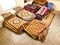 Ethnic carpet, ornamental folk bags, many ornate pillows with embroidery in asian shop, store. Asian market, trade fair in