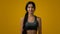 Ethnic happy smiling 20s woman Indian sport lady multiracial strong slender girl sports trainer runner posing in yellow