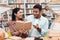 Ethnic indian mixed race girl and guy surrounded by books in library. Students are reding book.