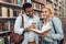 Ethnic indian mixed race guy and white girl in library. Students are looking for books.